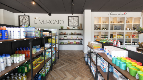 Interno del negozio 'Il Mercato' al Lago Idro Glamping Boutique con scaffali pieni di prodotti assortiti.