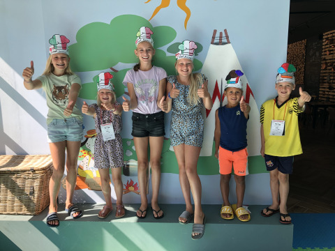Niños con gorros de chef sonríen y levantan el pulgar en Lago Idro Glamping Boutique, Lombardía, Italia.