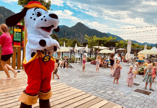 Children play near a dog mascot at Lago Idro Glamping Boutique holiday park in Lombardy, Italy.