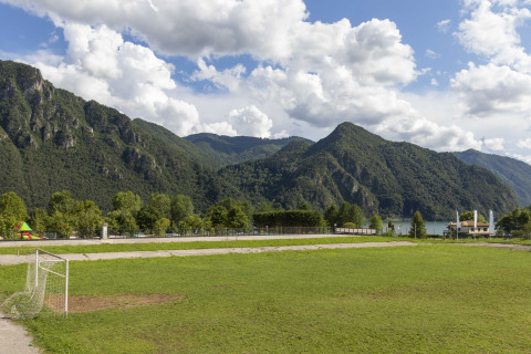 Fodboldbane med grønne bjerge og en sø i baggrunden ved Lago Idro Glamping Boutique i Lombardiet, Italien.