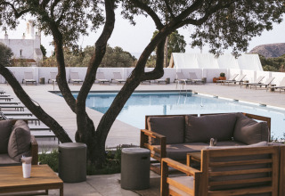 Area lounge all’aperto sotto un albero vicino alla piscina al Wecamp Cadaqués, villaggio in Catalogna, Spagna.