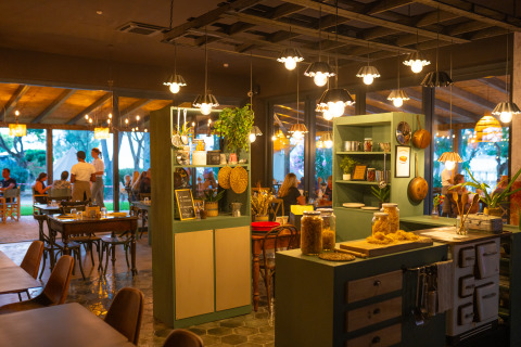Interno accogliente del ristorante al Trasimeno Glamping Resort in Umbria, Italia, clienti a cena.