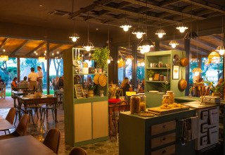 Interno accogliente del ristorante al Trasimeno Glamping Resort in Umbria, Italia, clienti a cena.
