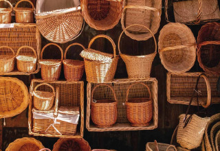 A variety of handwoven baskets and bags displayed in sunlight near Cadaqués, Girona, Catalonia, Spain.