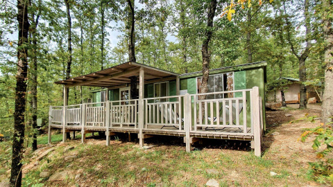 Cottage vert avec terrasse, entouré d’arbres au Chianti Glamping Resort en Italie, Cottage Classic.