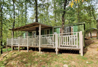 Cottage vert avec terrasse, entouré d’arbres au Chianti Glamping Resort en Italie, Cottage Classic.