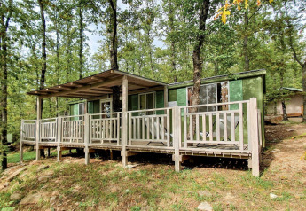 Cottage vert avec terrasse, entouré d’arbres au Chianti Glamping Resort en Italie, Cottage Classic.