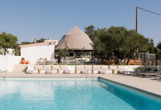 Outdoor pool area at Wecamp Cadaqués holiday park in Catalonia, Spain, featuring modern lounge seating.