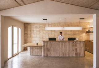 Receptie van Wecamp Cadaqués vakantiepark in Catalonië, Spanje, met een modern en minimalistisch interieur.