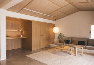 Modernes Wohnzimmer im Wecamp Cadaqués, Katalonien, Spanien mit Holzverkleidung und gemütlicher Couch.