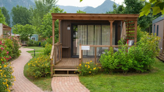 Cube Suite XL chalet met houten veranda, omringd door bloemen en groen, met bergen op de achtergrond.