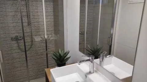 Salle de bain moderne au Cottage Spotty, Chianti Glamping Resort, Italie, avec double vasque et douche vitrée.