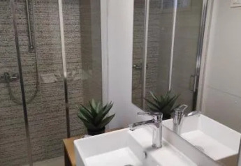Baño moderno en Cottage Spotty, Chianti Glamping Resort, Italia, con lavabo doble y ducha acristalada elegante.