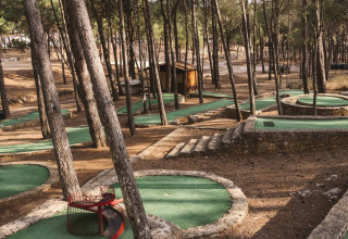 Parcours de mini-golf entouré de pins à Wecamp Cala Montgó, un parc de vacances en Catalogne, Espagne.