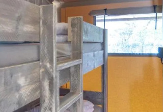 Interieur van Safari Tenten bij Chianti Glamping Resort in Italië met stapelbedden en raam.