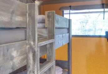 Indvendig udsigt af Safari Tenten på Chianti Glamping Resort i Italien med køjesenge og vindue.