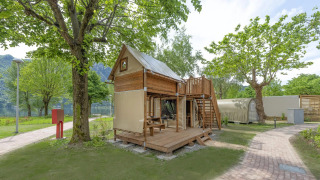 Beeld van een Air Dreamer safari tent met houten terras en dakterras, omgeven door groen.