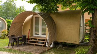Coco Suite pod met overdekt houten terras, tuinmeubilair en omgeven door groene natuur.