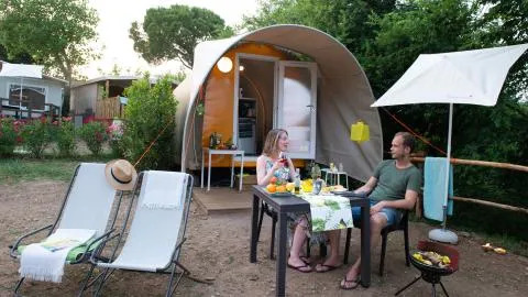 Twee personen genieten van een maaltijd aan een Coco Couple safaritent bij Chianti Glamping Resort, Italië.
