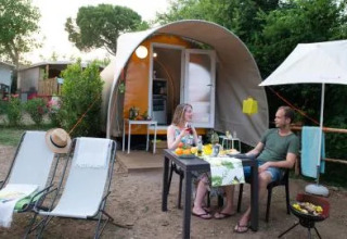 Twee personen genieten van een maaltijd aan een Coco Couple safaritent bij Chianti Glamping Resort, Italië.
