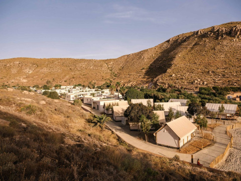 Vakantiepark met tenthuisjes in een droog, heuvelachtig landschap bij Wecamp Cabo de Gata, Andalusië, Spanje.
