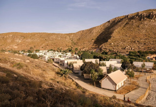 Vakantiepark met tenthuisjes in een droog, heuvelachtig landschap bij Wecamp Cabo de Gata, Andalusië, Spanje.