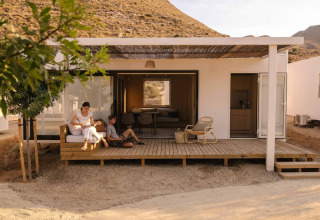 To personer slapper af på terrassen foran en moderne hytte i Wecamp Cabo de Gata, Andalusien, Spanien.