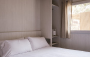 Slaapkamer in MOBIL HOME FAMILY WOOD bij Wecamp Cala Montgó, Spanje met dubbel bed en houten plafond.