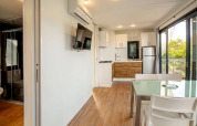Interno moderno di una lodge Cottage Next XL Panorama presso Trasimeno Glamping Resort, cucina e vista.