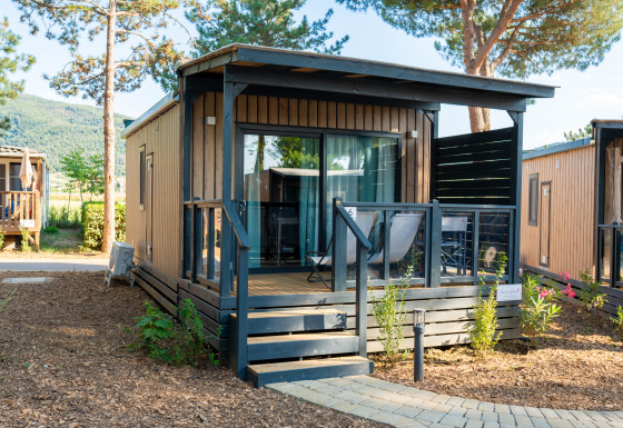 Cube Suite XL lodge met houten bekleding, gemeubileerd terras en groene natuuromgeving.