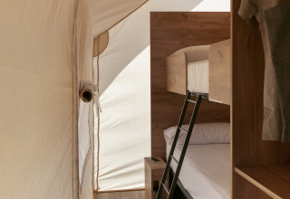 Interiør af en Glamping Family safaritelt på Wecamp Cabo de Gata i Spanien med køjesenge og trægulv.