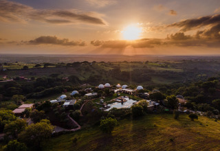 Coucher de soleil sur le parc de vacances Wecamp Reserva Alecrim à Alentejo, Portugal, entouré de collines.