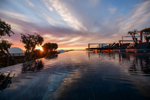 Zonsondergang aan het infinity zwembad van Wecamp Reserva Alecrim, midden in de natuur, Alentejo, Portugal.
