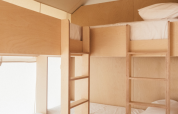 Interieur van Lodge «Grand Family» safaritent bij Wecamp Cádiz in Spanje, met lichte stapelbedden.