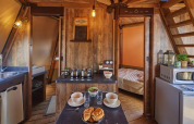 Interieur van Tipi Lodge bij Trasimeno Glamping Resort in Italië, met keuken en comfortabele slaapkamer.