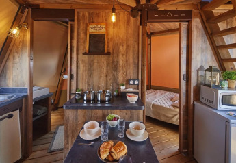 Interieur van Tipi Lodge bij Trasimeno Glamping Resort in Italië, met keuken en comfortabele slaapkamer.