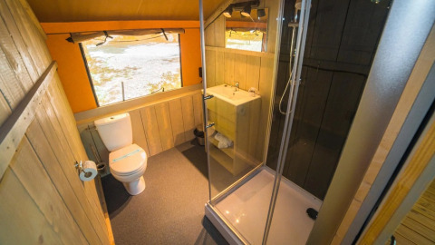 Badkamer in de safaritent 'Spotty Lodge' Ranger met douche, toilet en wastafel bij Trasimeno Glamping Resort.