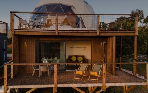 Dome House Duplex bij Wecamp Reserva Alecrim in Portugal met twee houten terrassen en buitenzitplaatsen.