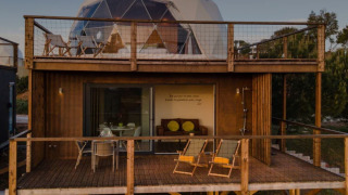 Dome House Duplex en Wecamp Reserva Alecrim, Portugal, con dos terrazas de madera y asientos exteriores.