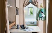 Vista interna di una tenda safari Coco Suite al Trasimeno Glamping Resort in Italia, con cucina e camera da letto.