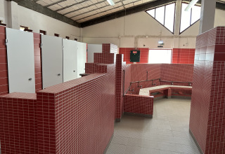 Moderne badefaciliteter med røde og hvide fliser på Wecamp Sao Miguel feriepark i Alentejo, Portugal.
