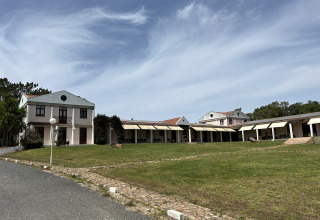 Wecamp Sao Miguel vakantiedomein in Alentejo, Portugal met gebouwen, grasveld en blauwe hemel.