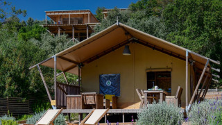 Tienda safari Lodge Family en Wecamp Reserva Alecrim, Portugal, rodeada de vegetación y terraza al aire libre.