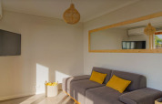 Woonkamer van Bungalow Comfort Family bij Wecamp Reserva Alecrim, Portugal, met zetel en gele kussens.