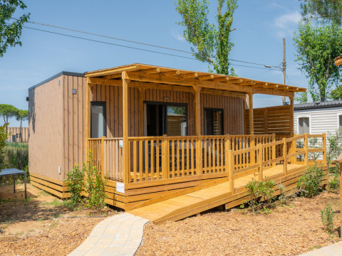 Cabaña Cottage Next XL 4 All con terraza de madera, rampa de acceso y rodeada de naturaleza.