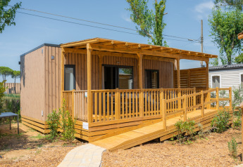 Cabaña Cottage Next XL 4 All con terraza de madera, rampa de acceso y rodeada de naturaleza.