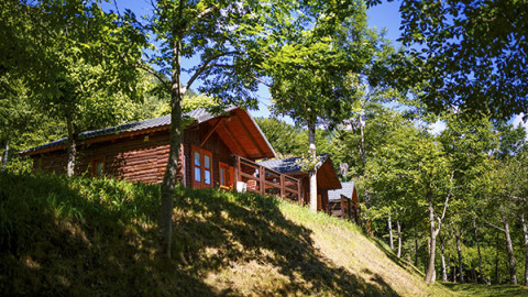 Bungalow in legno immersi nel verde al campeggio Bedura Park, un villaggio turistico in Catalogna, Spagna.