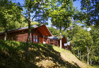 Bungalow in legno immersi nel verde al campeggio Bedura Park, un villaggio turistico in Catalogna, Spagna.