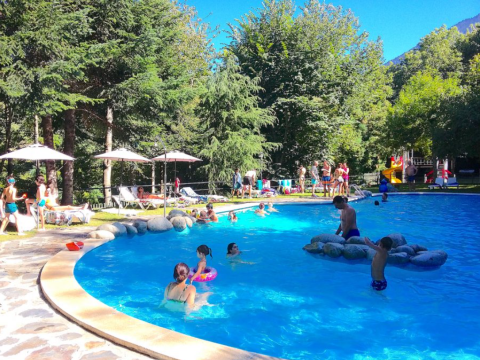 Famiglie che si divertono nella piscina del campeggio Bedura Park, un villaggio vacanze in Catalogna, Spagna.