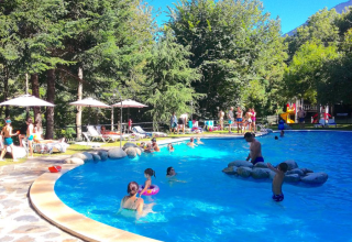 Families enjoying a sunny day by the pool at Campsite Bedura Park, a holiday park in Catalonia, Spain.